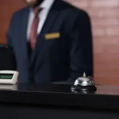 Recepcjonista w hotelu czeka przy ladzie. Zastanawiasz się, ile zarabia recepcjonistka w hotelu?