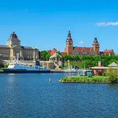 Widok na port w Szczecinie z budynkami muzealnymi i statkiem na wodzie.