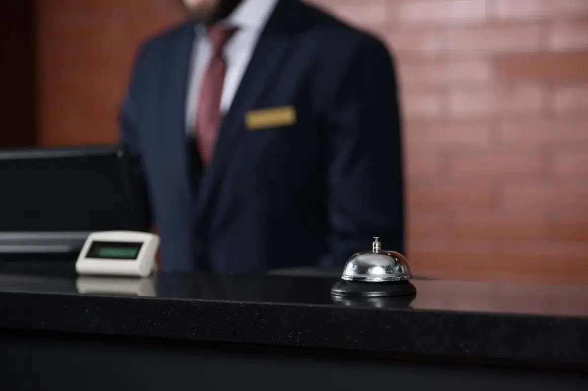 Recepcjonista w hotelu czeka przy ladzie. Zastanawiasz się, ile zarabia recepcjonistka w hotelu?