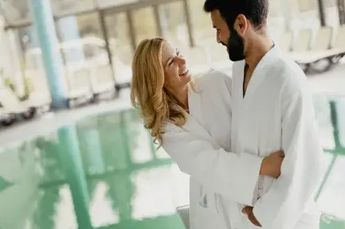 osoba w szlafroku idąca korytarzem hotelowym