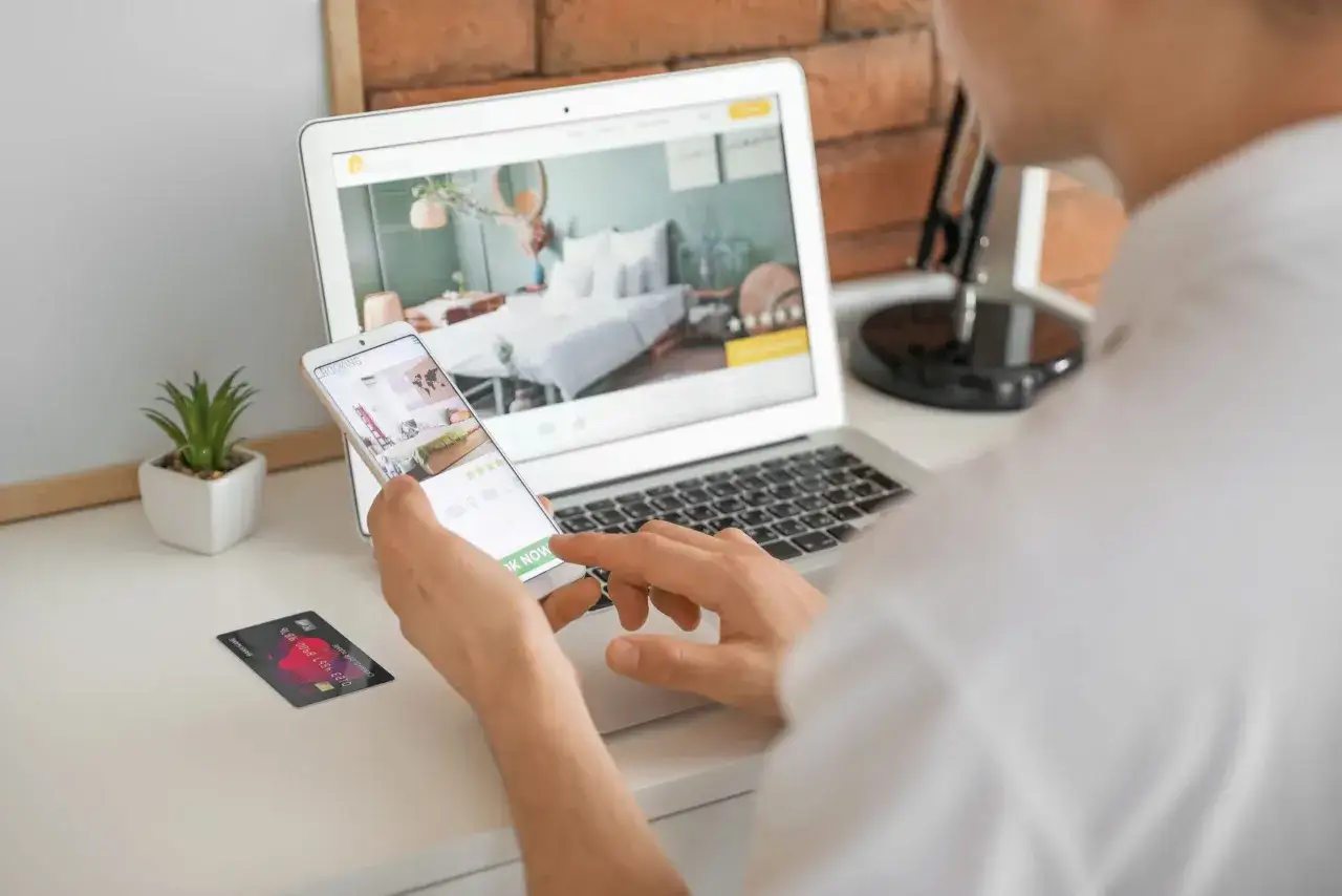 Osoba rezerwująca hotel online na laptopie